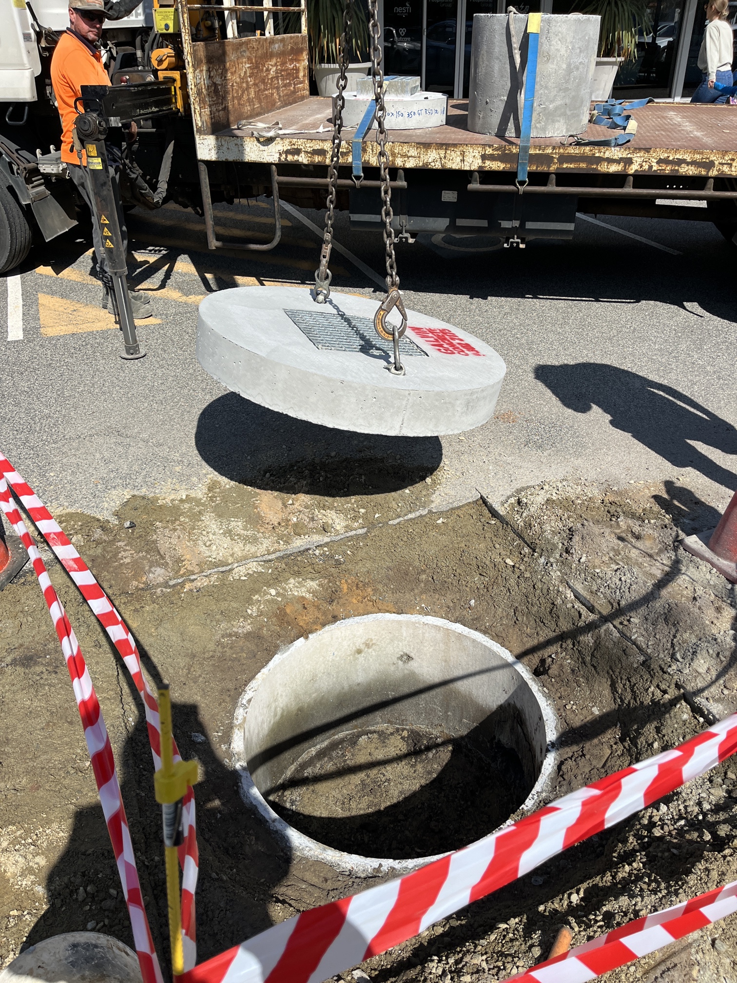 Concrete soakwell lid being lifted with a hoist during stormwater system inspection.