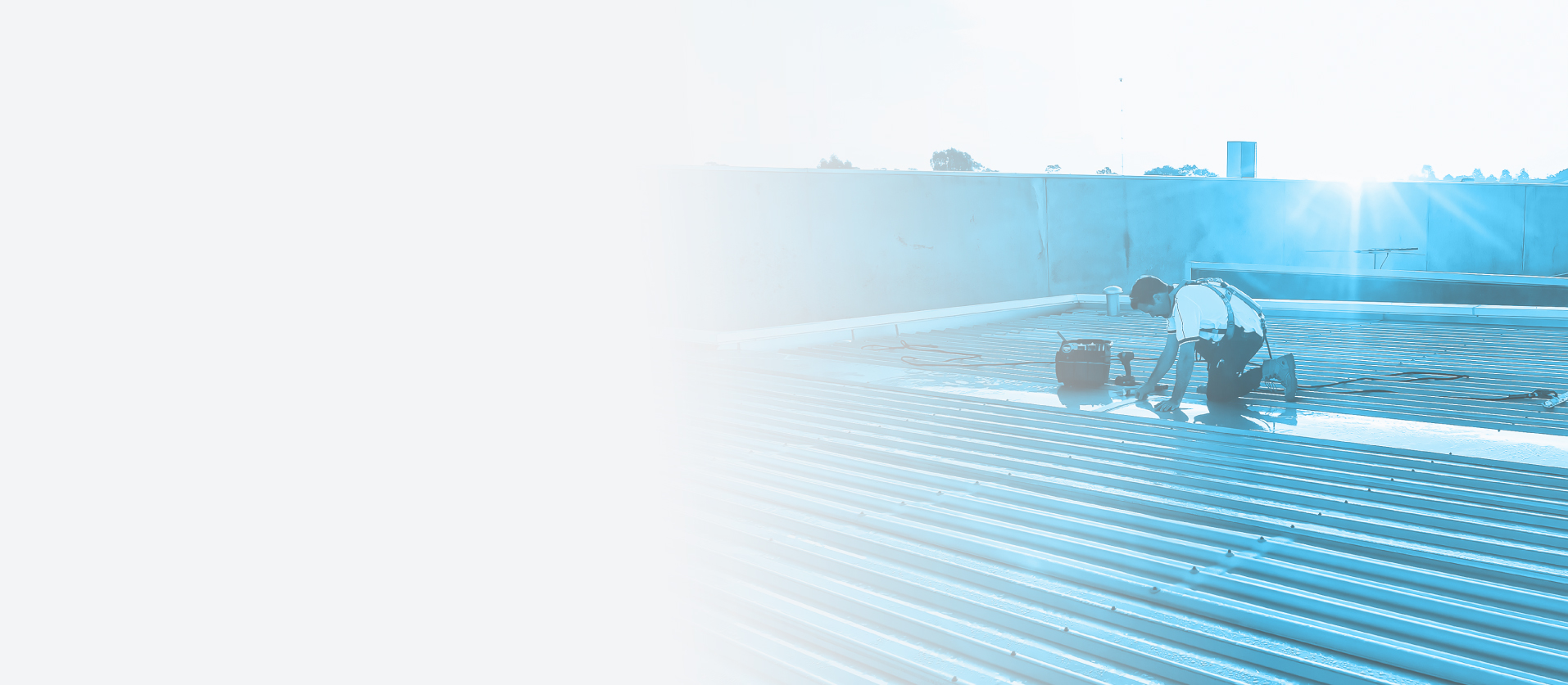 Roofer carrying out commercial roof repairs on metal sheeting